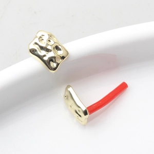 Detailed view of hammered gold irregular earring findings with textured metal surface