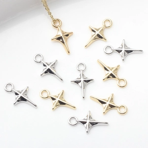 Dettaglio di mini ciondoli a croce stellata in oro e argento per gioielli fai-da-te