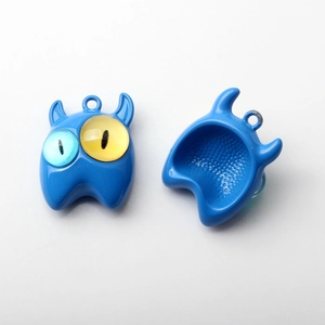 Detailansicht der Vorder- und Rückseite eines blauen kleinen Monster-Anhängers aus Legierung