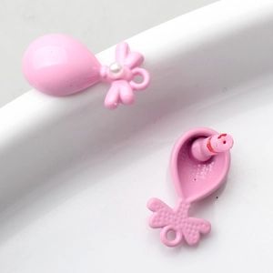 Gedetailleerde weergave van roze ballonhangers van legering met strik en parelaccent