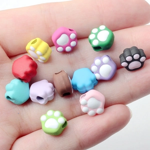 Colorful silicone cat paw beads held in hand for DIY jewelry making accessories