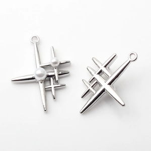 Close-up of starburst cross pendants in silver alloy with pearl accents for DIY jewelry
