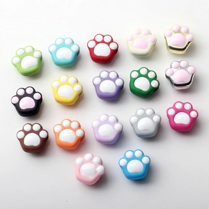 Close-up of colorful cat paw alloy charms in various pastel colors for DIY jewelry making