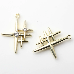 Macro detail of gold star charms with inset white rhinestones and a top hanging loop