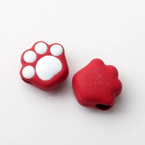 Detail of red cat paw silicone beads with white pads and pre-drilled holes for DIY