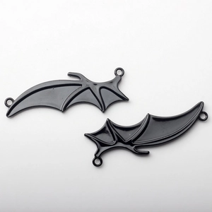 Detailed view of black enamel bat wing charms with dual rings for DIY jewelry crafting