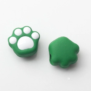 Detail of green and white cat paw beads for DIY jewelry with side holes and soft texture