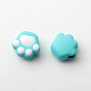 Macro view of light blue cat paw charms with white pads for DIY jewelry accessories