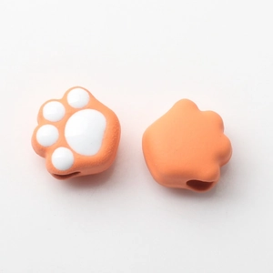 Macro detail of cute orange and white cat paw beads for DIY jewelry and accessories