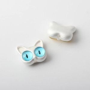 Detalle macro de cuentas de gato con ojos azules y acabado perlado para joyería DIY