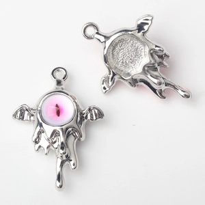 Detailed view of alloy bat wing pendant with pink eyeball for DIY jewelry making