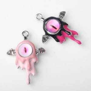 Detail of gothic eyeball pendant with pink iris and bat wings for DIY jewelry