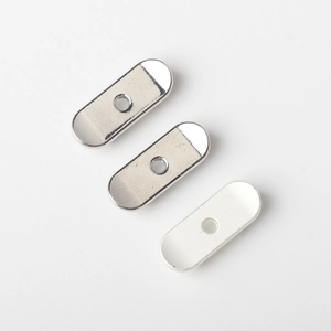 Detailed close-up of oval alloy skateboard pendant charms with polished and matte finish