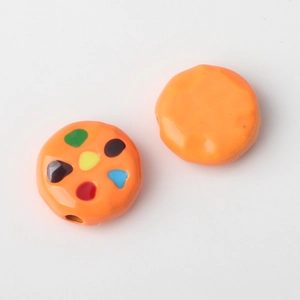 Detail of orange round alloy beads with colorful dots and pre-drilled holes for DIY jewelry