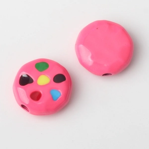 Macro detail of pink alloy beads with colorful dots and glossy finish for DIY jewelry making