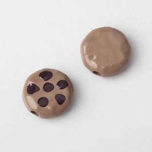 Macro detail of cookie-shaped resin beads for DIY jewelry with small threading holes