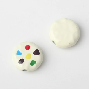 Detail of cream enamel beads with colorful dots for DIY jewelry making and crafts