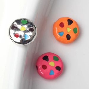 Close-up of colorful cookie-shaped charms with enamel finish for DIY jewelry making