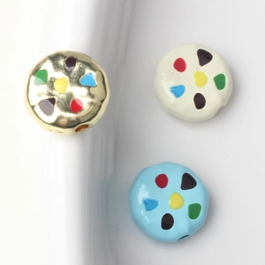 Detail of colorful alloy beads with vibrant enamel dots and threading holes for DIY jewelry