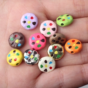 Colorful cookie-shaped alloy beads for DIY jewelry making displayed on a palm