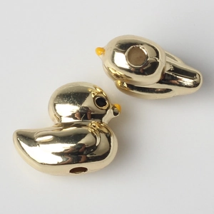 Macro shot of two golden duck charms with pre-drilled holes for DIY jewelry making
