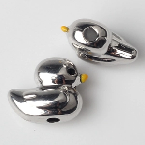 Detailed view of silver duck beads with yellow beaks for DIY jewelry making