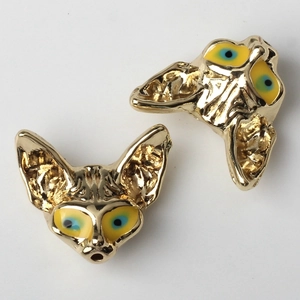 Vue détaillée de pendentifs tête de renard dorée avec yeux en émail bleu et jaune