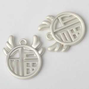 Close-up of matte silver Fu character hollow pendants with wing design for DIY jewelry