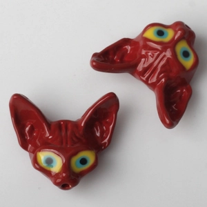 Détail macro d'un pendentif renard en céramique rouge avec yeux bleus pour bijoux