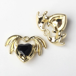 Makroaufnahme von Herzanhänger mit Fledermausflügeln und schwarzem Stein für DIY Schmuck
