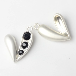 Macro view of silver alloy heart pendants with black faceted stones and back structure
