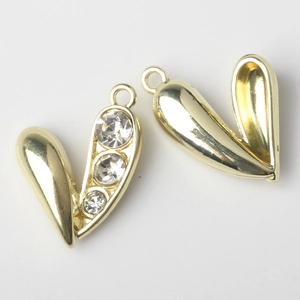 Macro view of gold heart pendants featuring one smooth and one rhinestone-set alloy design