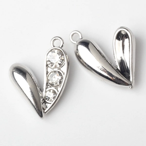 Macro view of V-shaped heart pendants with silver metal finish and three inlaid rhinestones