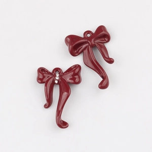Detalle de colgantes de lazo en esmalte rojo oscuro con diamantes para joyería DIY