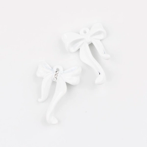 Detalle de colgantes de lazo en esmalte blanco con cristales pequeños para joyería DIY