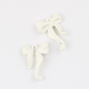 Detalle macro de colgantes de lazo en esmalte crema con cristales para joyería DIY