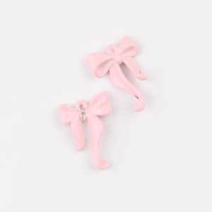 Detalle de colgantes de lazo rosa con cristales brillantes para creación de joyas DIY