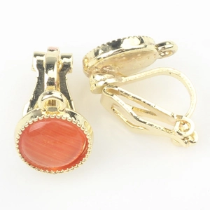 Nahaufnahme goldener Clip-Ohrringe mit orangefarbenem Katzenauge und Vintage-Perlenrand