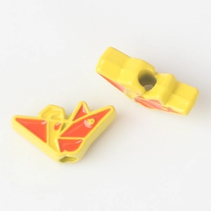 Detail of origami crane alloy beads with yellow and orange enamel finish for jewelry DIY