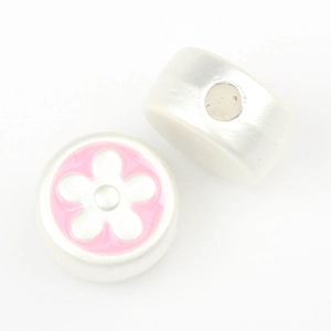 Close-up of silver-tone round beads with pink enamel flower for DIY jewelry making