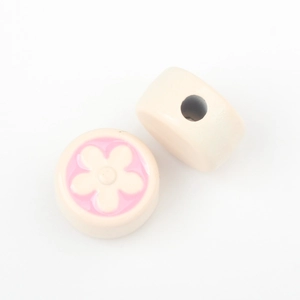 Close-up of cream round beads with pink flower patterns for DIY jewelry making