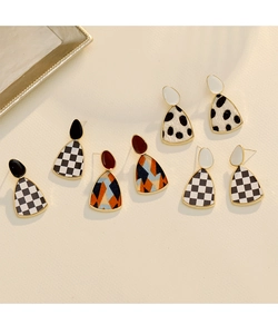 Gros plan de boucles d'oreilles géométriques avec motifs léopard et damier rétro