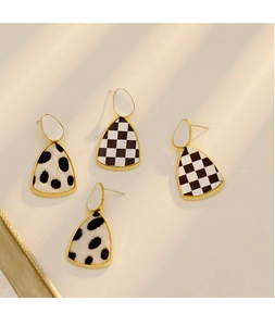 Détail de boucles d'oreilles en tissu à damier et à pois avec monture dorée