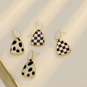 Boucles d'oreilles vintage à damier et imprimé vache, bordure dorée sur fond épuré