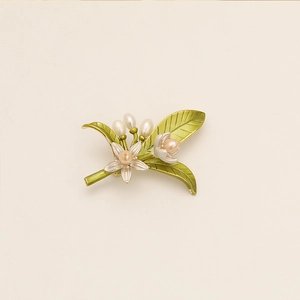 Elegante spilla a fiore con foglie verdi e perle bianche su sfondo minimalista
