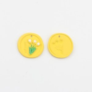 Detailansicht des gelben Blumenanhängers mit miss you Text und geprägtem Tulpenchemie