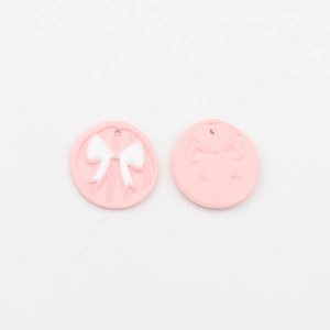 Detailansicht der Vorder- und Rückseite rosa Schleifen-Anhänger mit Relief-Struktur