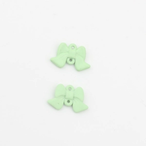 Detail von zwei mintgrünen Anhängern in Schleifenform mit Doppelösen für DIY-Schmuck