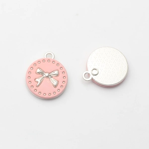 Vorder- und Rückansicht eines rosa Emaille-Anhängers mit silberner Schleife für DIY-Schmuck