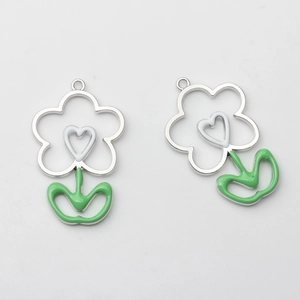 Makroaufnahme weißer hohler Blumenanhänger mit grünen Emailleblättern und Silberring